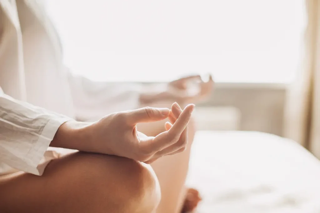 Close-up of a person meditating in a calm space, symbolizing mindfulness and self-reflection in aligning yourself for love with the I Ching and questions like Does he love me? Does she love me?